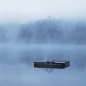 Wooden dock floating in still lake
