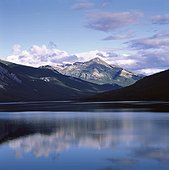 Rocky mountains and sky reflected in still lake