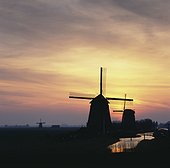 Silhouette of windmills in rural landscape