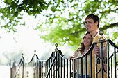 Smiling couple leaning on railing outdoors