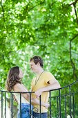 Smiling couple leaning on railing outdoors