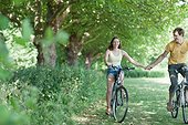 Couple holding hands and riding bicycles
