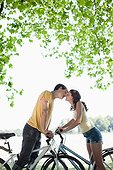 Couple on bicycles stopping and kissing