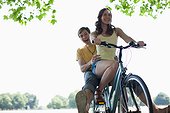 Smiling woman riding boyfriend on bicycle
