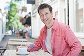 Smiling man drinking coffee in cafe