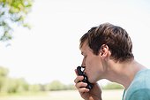 Man kissing cell phone outdoors