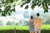 Couple hugging outdoors looking at landscape