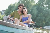 Smiling couple in rowboat on lake