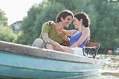 Couple hugging in rowboat on lake