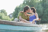Couple kissing in rowboat on lake