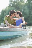 Couple hugging in rowboat on lake