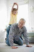 Grandfather crawling with grandson on back