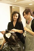 Hair stylist teaching student in salon