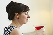 Woman drinking cocktail in living room