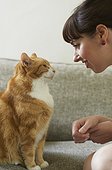 Woman talking with cat on sofa