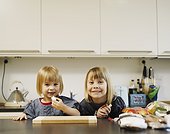 Smiling girls eating in kitchen