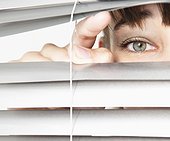 Woman peeking through blinds