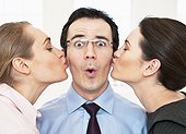 Businesswomen kissing colleagues cheeks