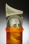 Close up of U.S. dollars in pill bottle