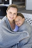 Mother and daughter wrapped in blanket