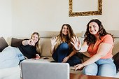 Female friends on video call, waving