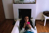 Young woman on sofa, looking at mobile phone