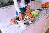 Woman unpacking vegetables in kitchen