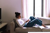 Young woman reading on sofa
