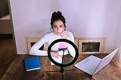 Young woman having video call, using ring light and phone