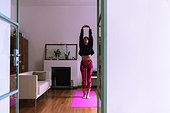 Young woman standing on yoga mat