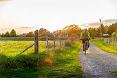 Man mountain biking on rural path