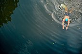 Man wild swimming in river, overhead view, River Wey, Surrey, UK
