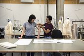 Fashion students, man measuring woman's arm