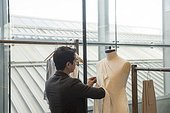 Fashion student working on garment on mannequin