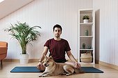 Man sitting on exercise mat with pet dog