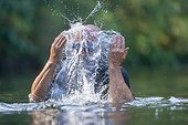 Swimmer in river, splashing water on face