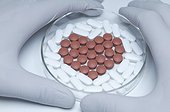 Gloved hands holding a petri dish with generic pills forming heart symbol