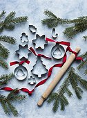Metal cookie cutters of different shapes with rolling pin