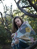 Young woman outdoors, wrapped in blanket