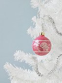 Pink ornament on a white Christmas tree