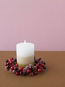 Single candle with a berry wreath
