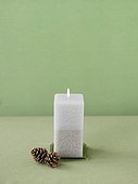 Single pillar candle with pinecones