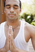 Man with hands clasped doing yoga
