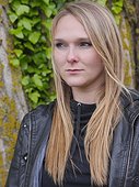 Young woman in leather jacket looking away