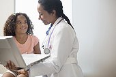 Pediatrician showing girl (6-7) laptop