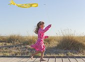 Young girl playing with a kite.