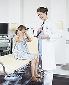 doctor examing child, using stethoscope, smiling