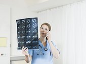 female doctor looking at CT x-rays, using smart phone