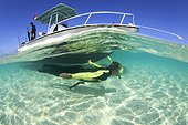 snorkeller diving down a boat in the bahamas