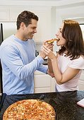 Husband Feeding His Wife Homemade Pizza